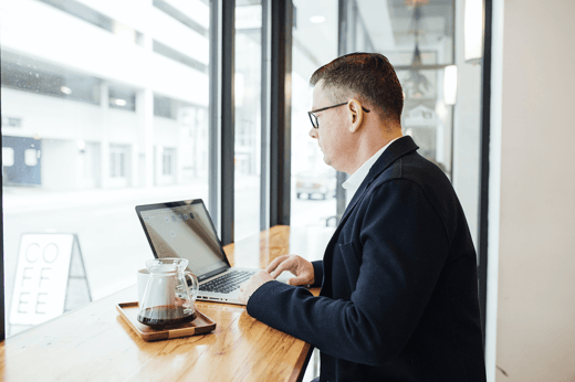 business man drinking coffee windown laptop