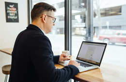Man on laptop at coffee shop bar